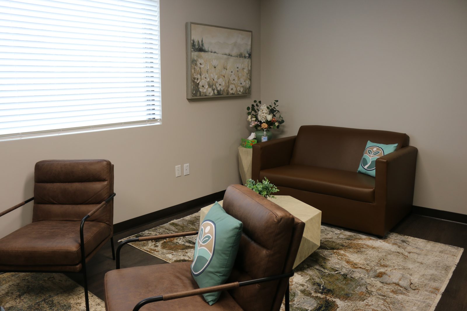 A therapy room at PATH Health Services in Tempe: two leather armchairs and a small sofa around a low table, with a window along one wall
