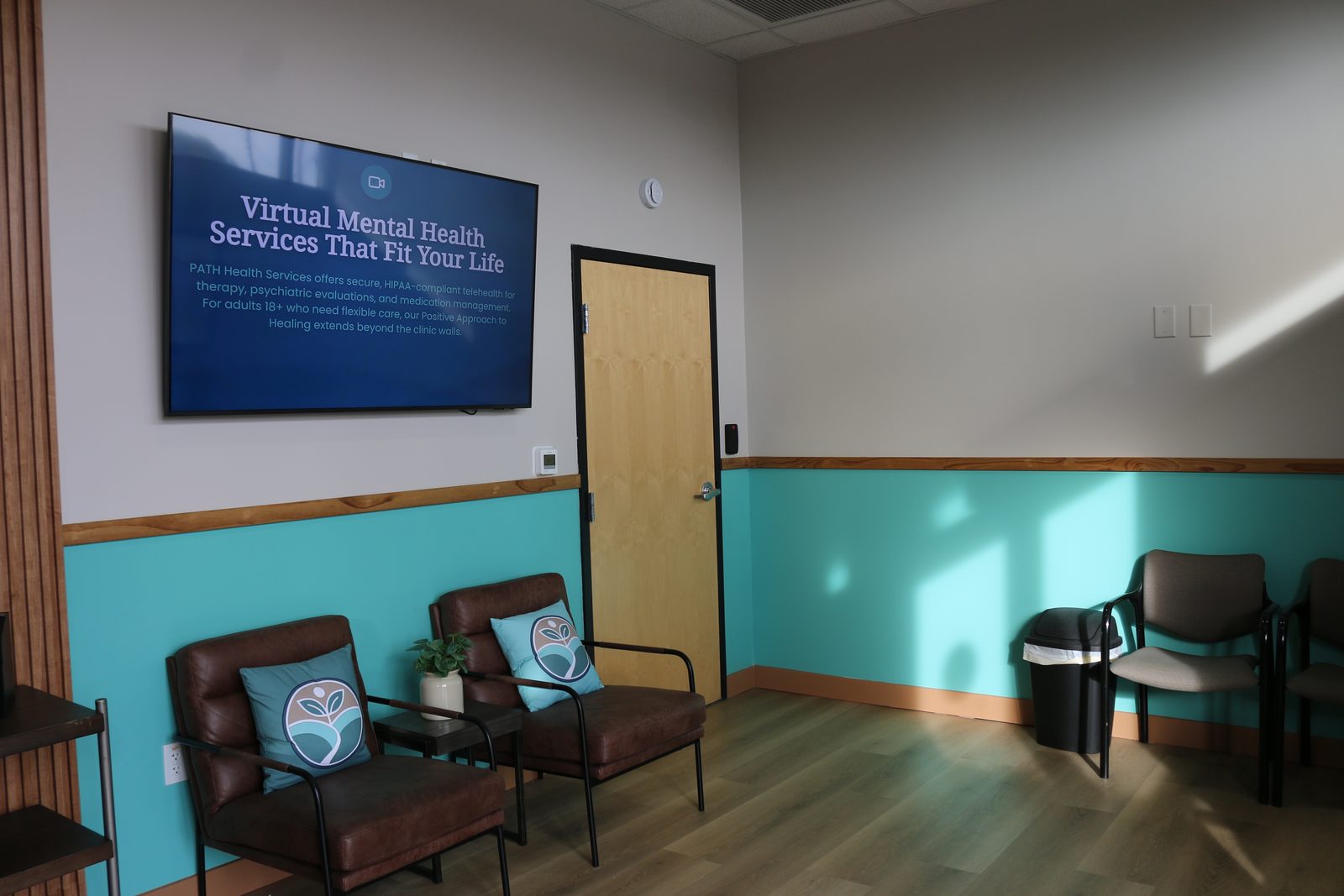 The PATH Health Services waiting room in Tempe: leather armchairs, a plant, and a screen on the wall